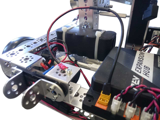 An expansion hub with a grounding cable connected to the XT30 port and bolted to the metal frame of the robot.