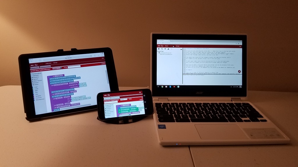 A tablet, a phone, and a laptop each showing the programming tools in use.