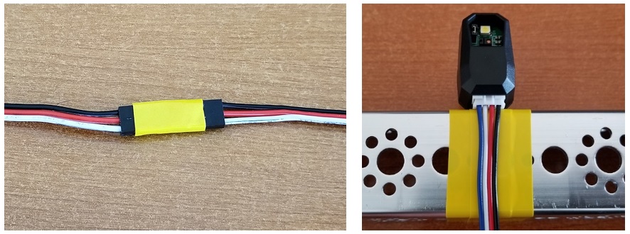A servo wire extension connection wrapped in electrical tape and a sensor mounted on a frame where the frame is wrapped in electrical tape.